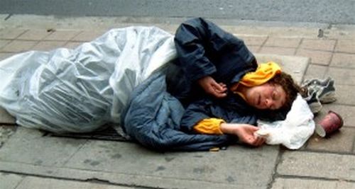 Sleeping on
            cement, a homeless woman braves icy cold. A regular scene in
            America these days.